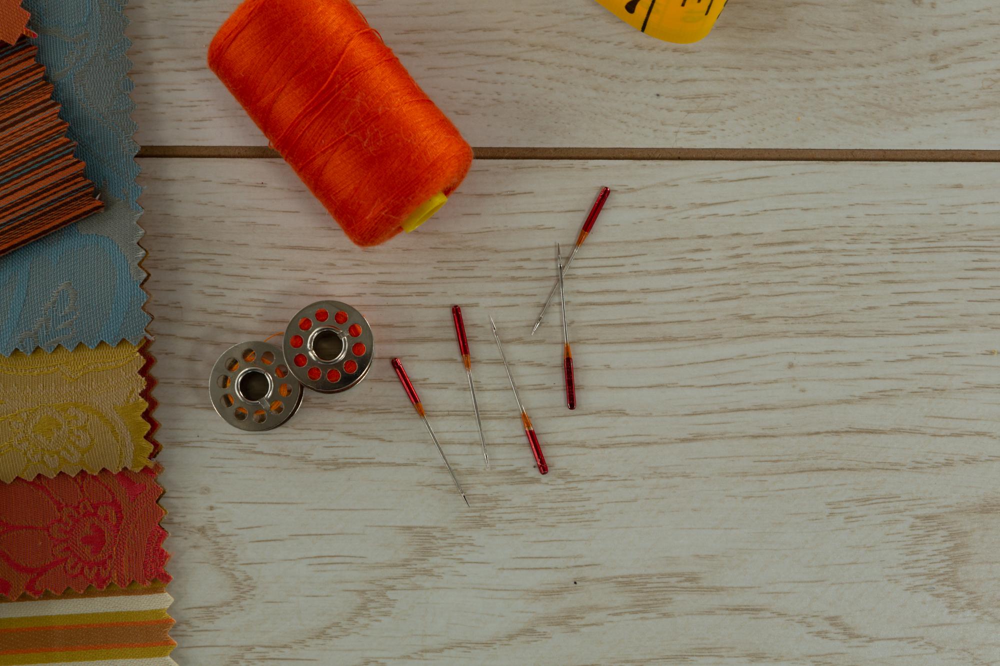Studio workspace with threads and fabric samples on table